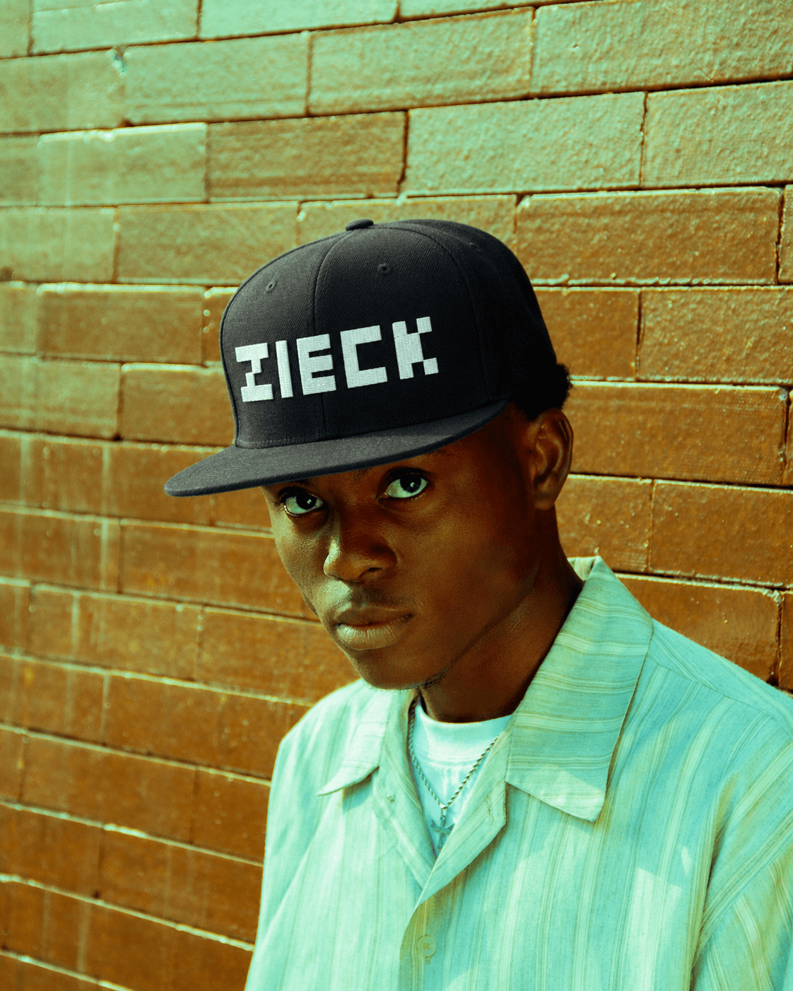 Person wearing the Zieck pixel-wordmark snapback against a brick wall